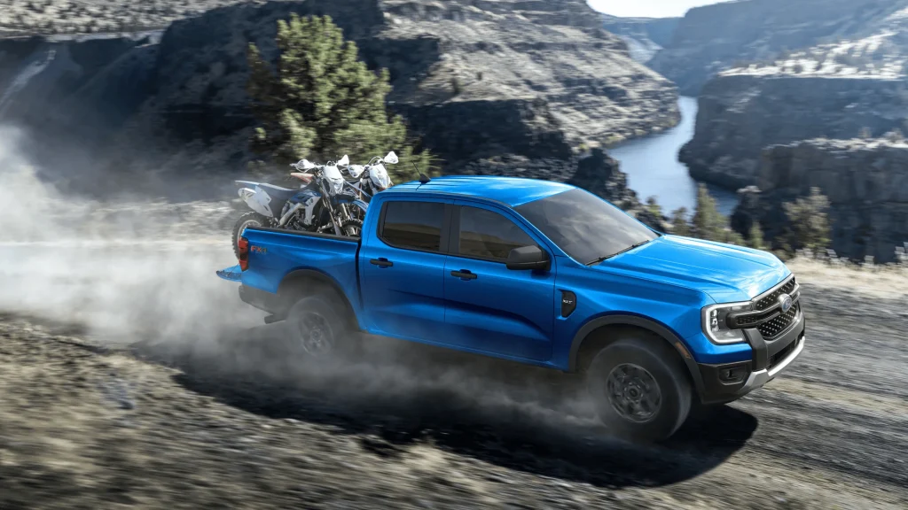 2025 Ford Ranger hauling dirt bikes on a dusty trail near Cleveland’s scenic outdoors.