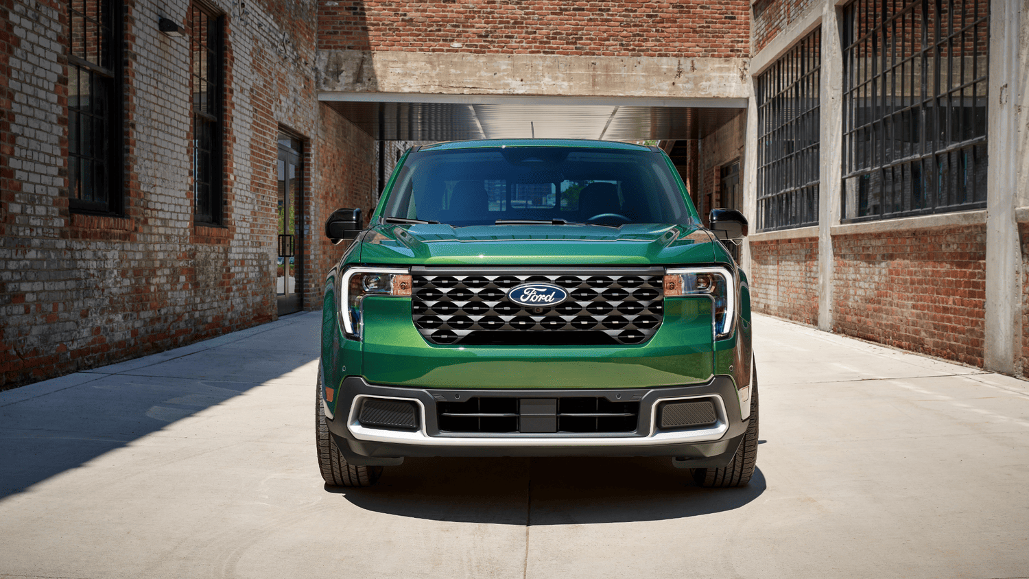 Bold front view of the 2025 Ford Maverick® in a striking green finish, parked in an urban alley in Euclid, OH.