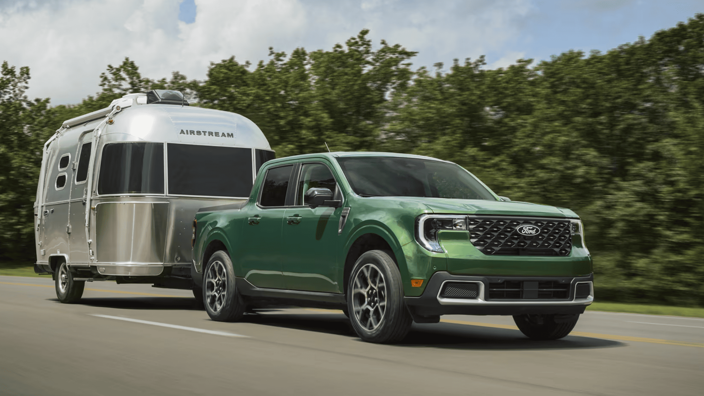 A 2025 Ford Maverick® towing a camper trailer, showcasing its powerful capabilities on a scenic road in Cleveland, OH.
