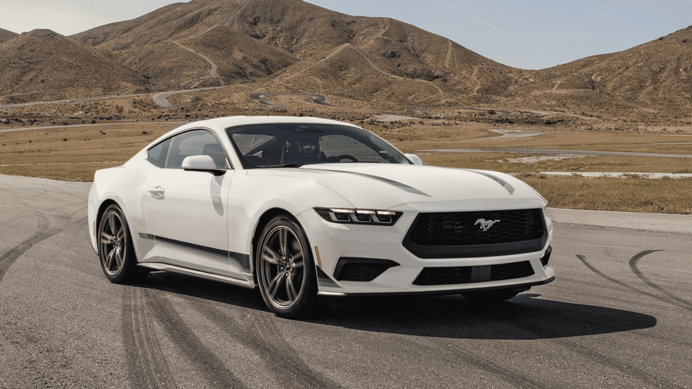 A 2025 Ford Mustang® navigates a scenic mountain road in Cleveland, OH, highlighting its sporty look and dynamic driving capabilities.