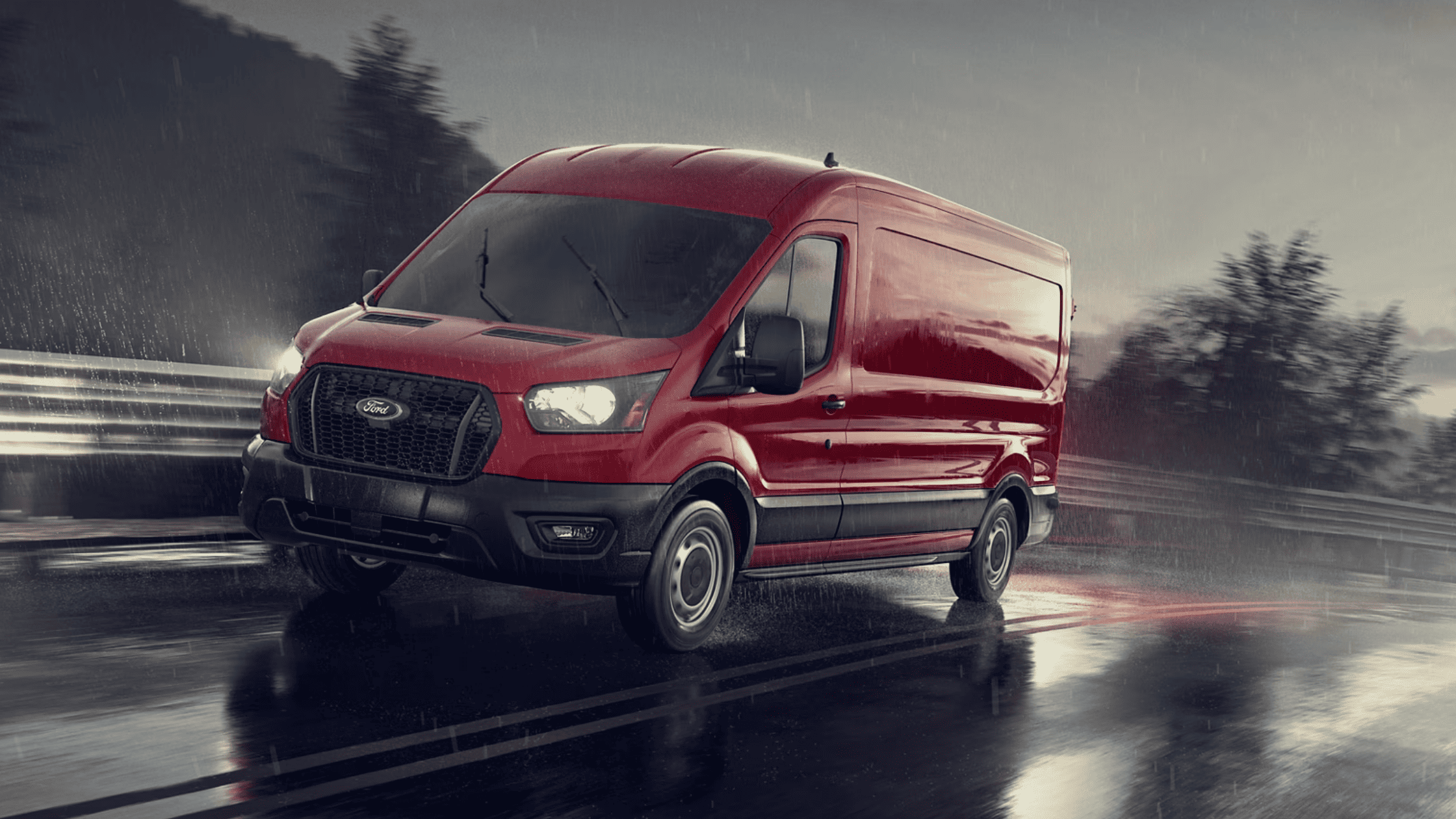 A 2025 Ford Transit® Van drives on a wet road in Cleveland, OH, showcasing its performance in challenging weather conditions.